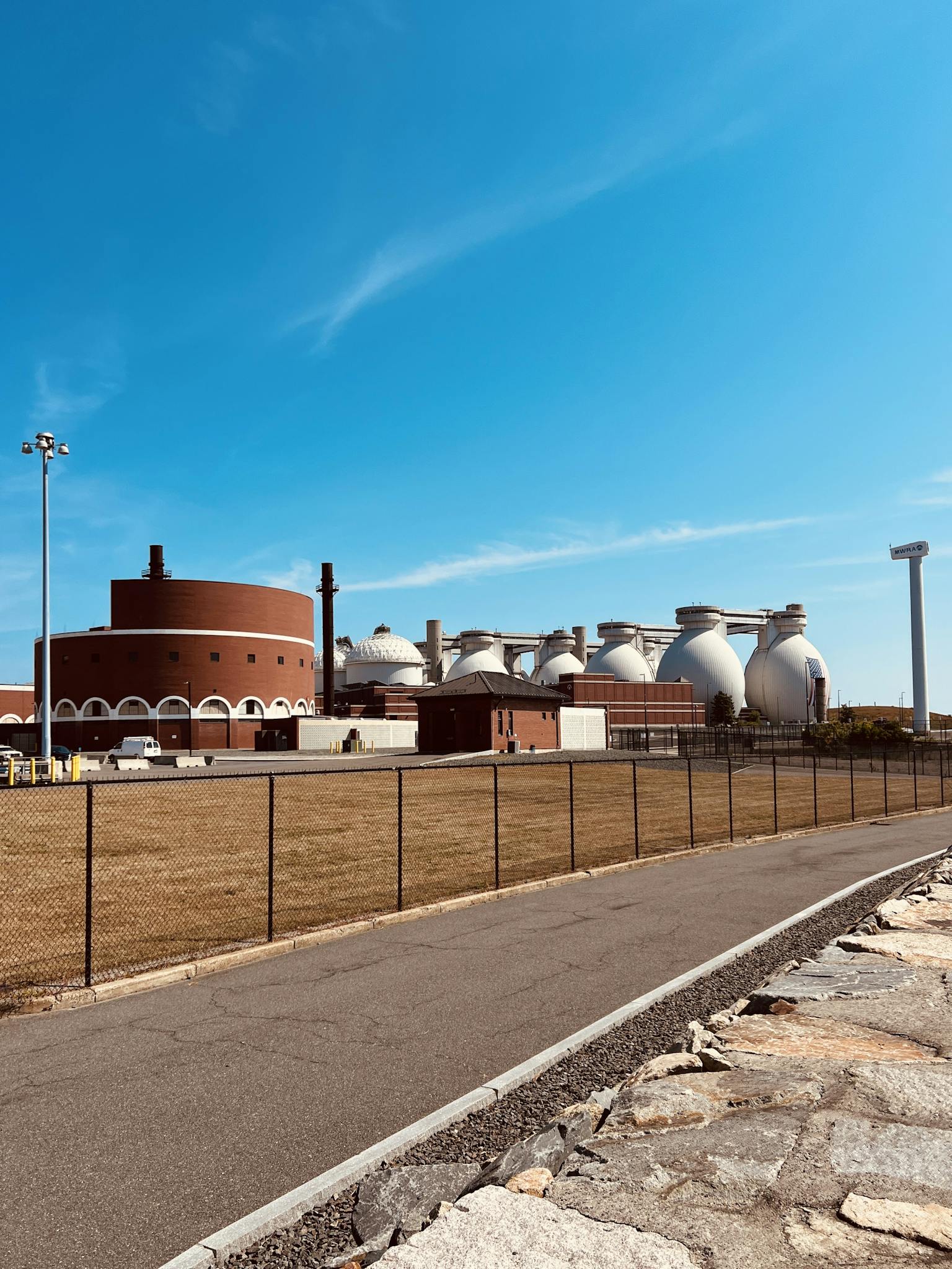 Water treatment plant with domed tanks and clear sky. Urban infrastructure and environmental technology.